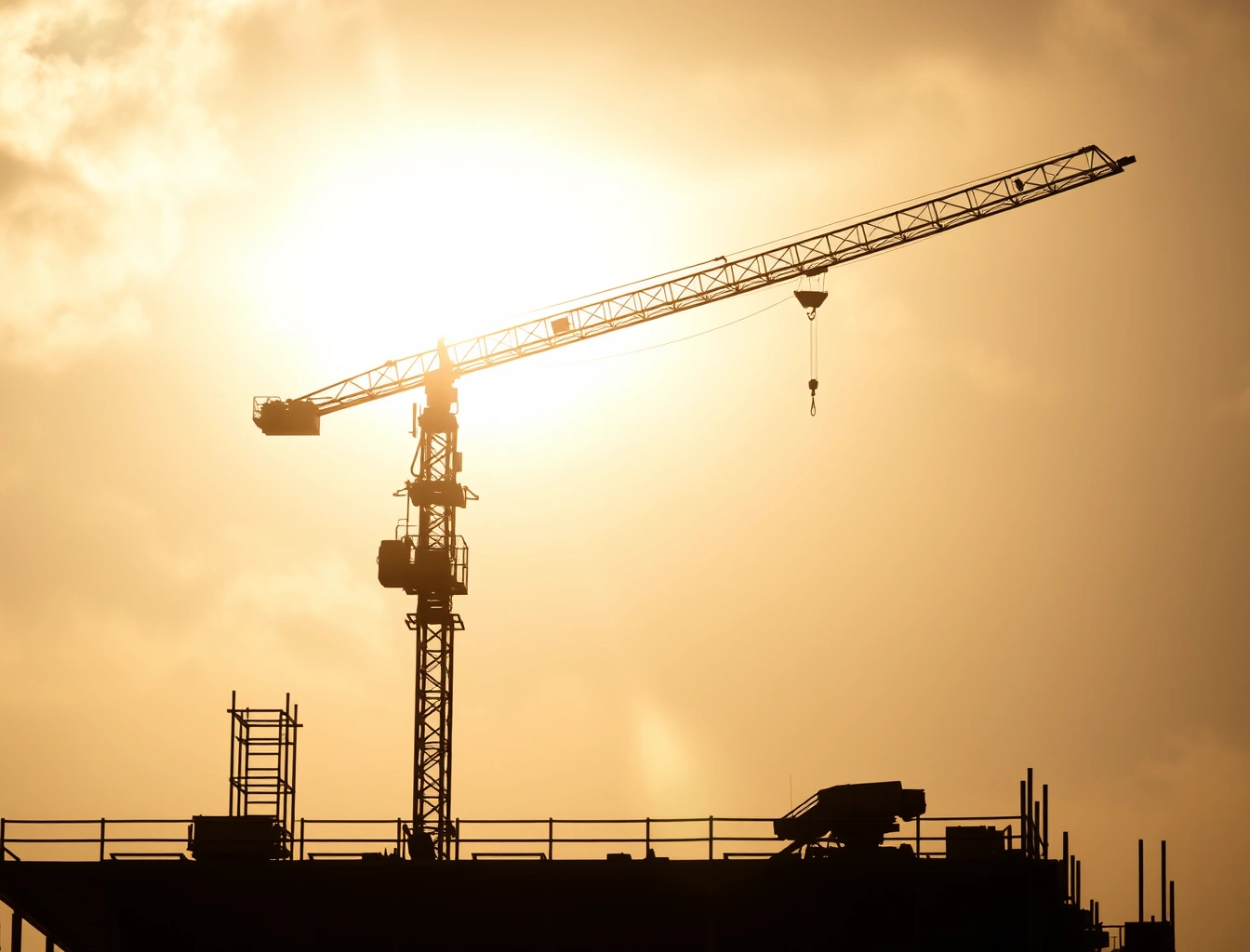 Grua de pequeno porte instalada na laje de um edifício em construção, com lança estendida