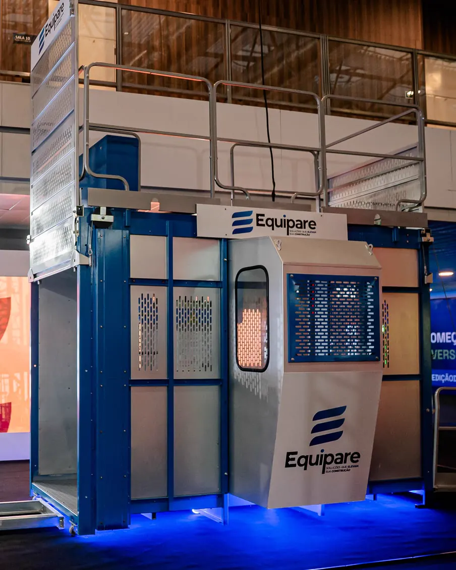 Elevador cremalheira Equipare montado: cabine com visor do operador, painel de comando, mastro azul e a marca aplicada
